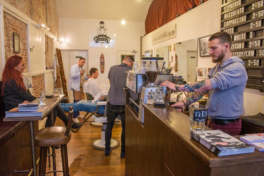 Barista och besökare på kafe och barberare Cut Throat i Amsterdam
