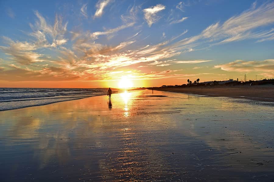 Solnedgång över strand i Huelva i Andalusien