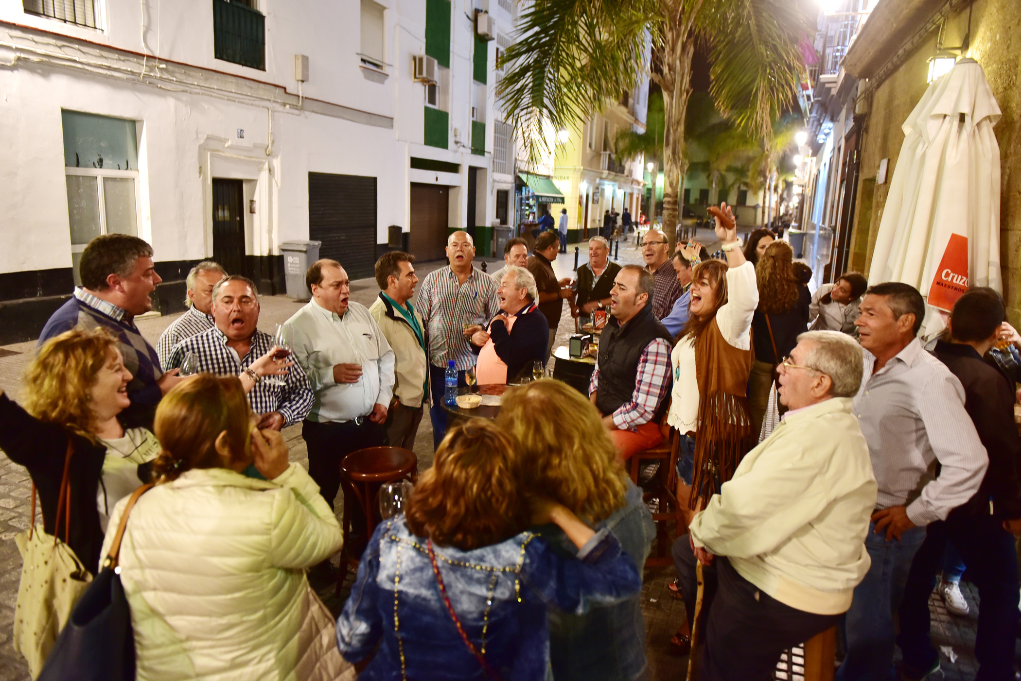 Människor som är glada på gata utanför bar i Andalusien.