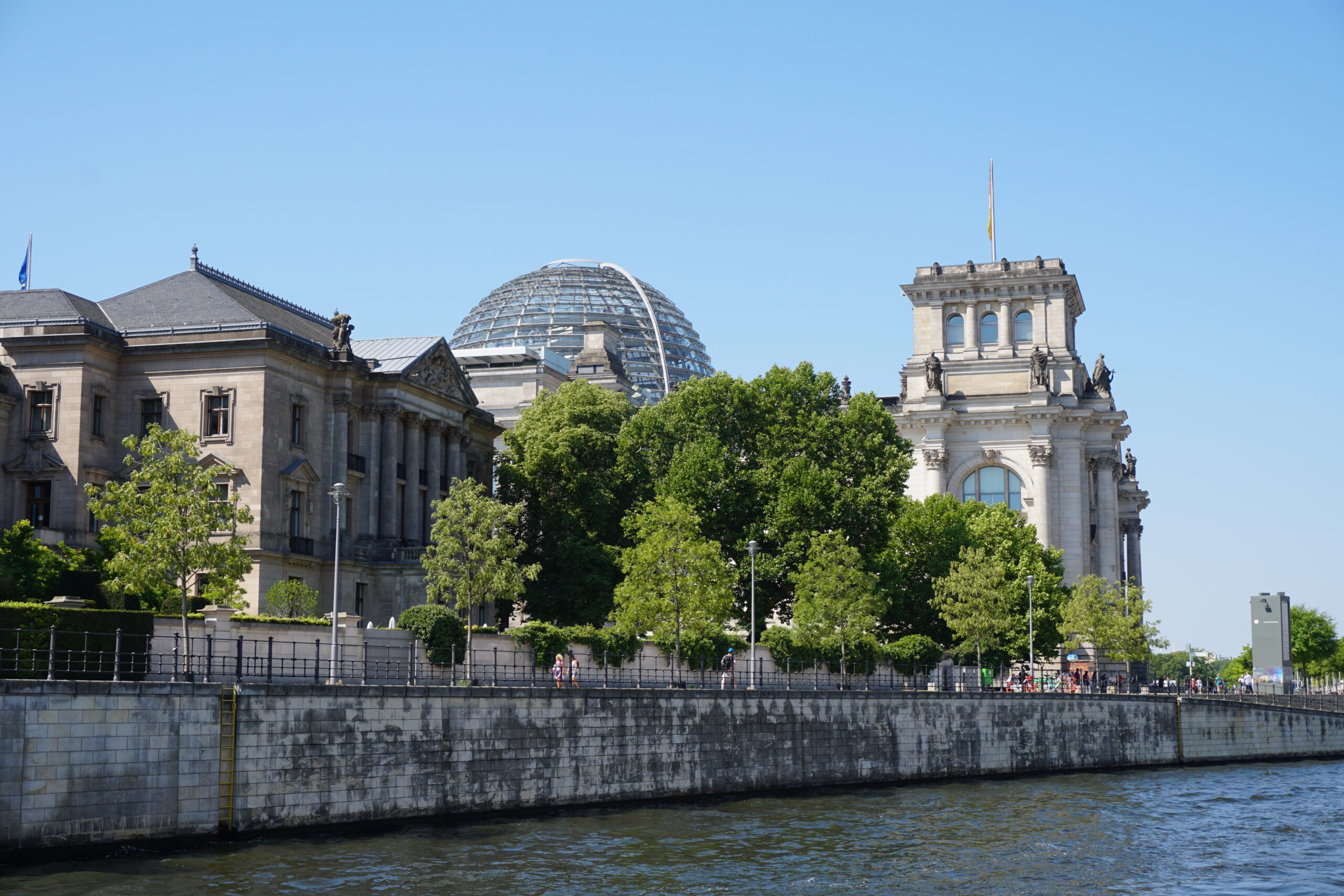 Vy över floden Spree och gamla hus i Berlin en solig sommardag.