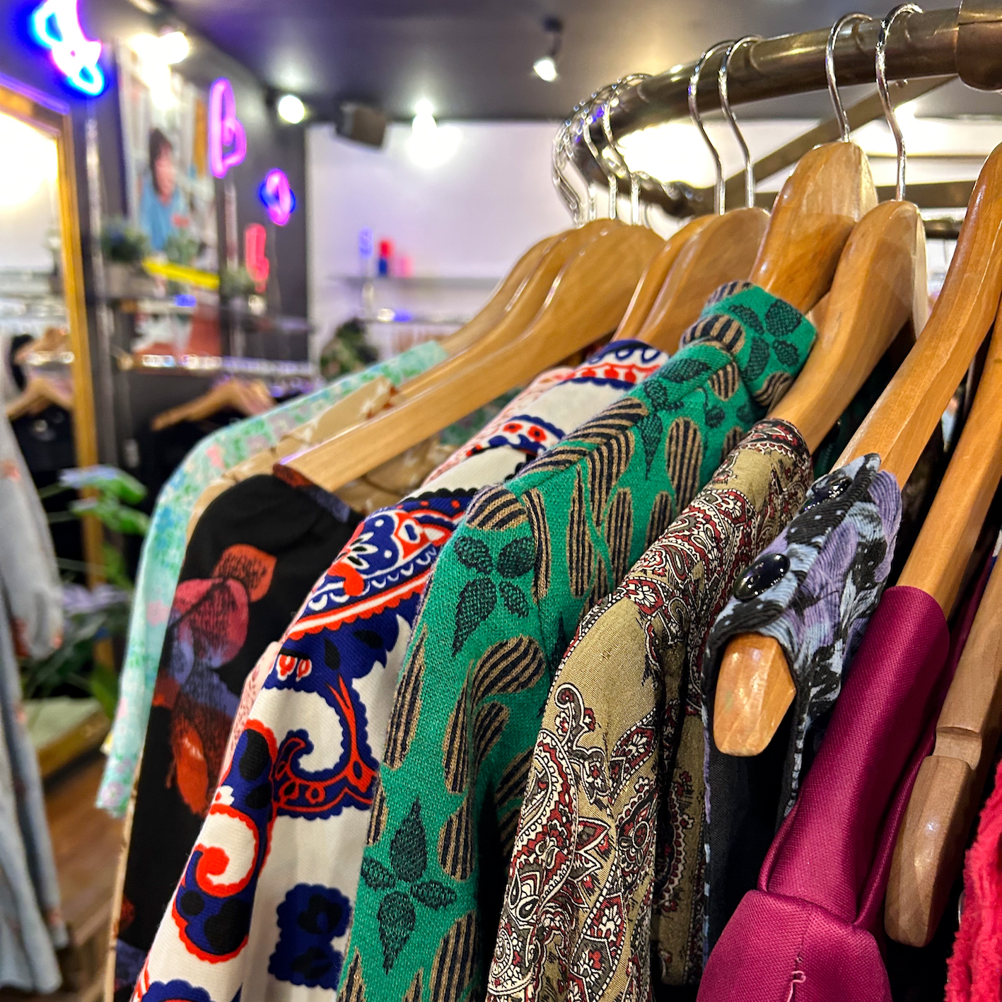 Kläder hänger på galgar i second hand i London: Atika.