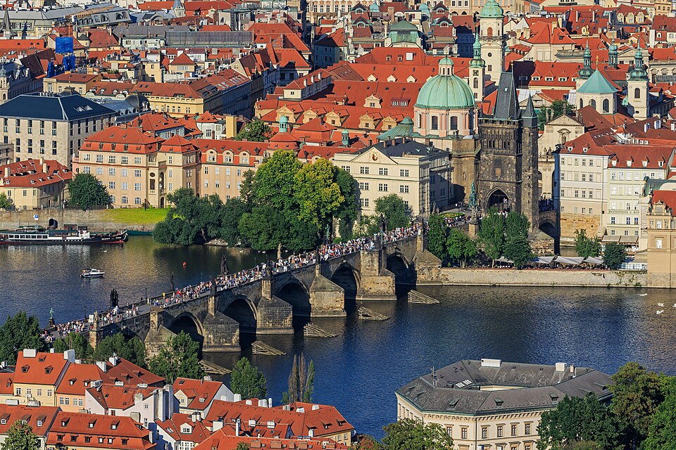 Bro med människor över floden en solig dag i Prag