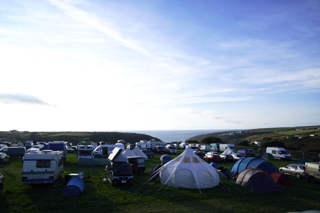 camping, tält och vans parkerade med utsikt över havet