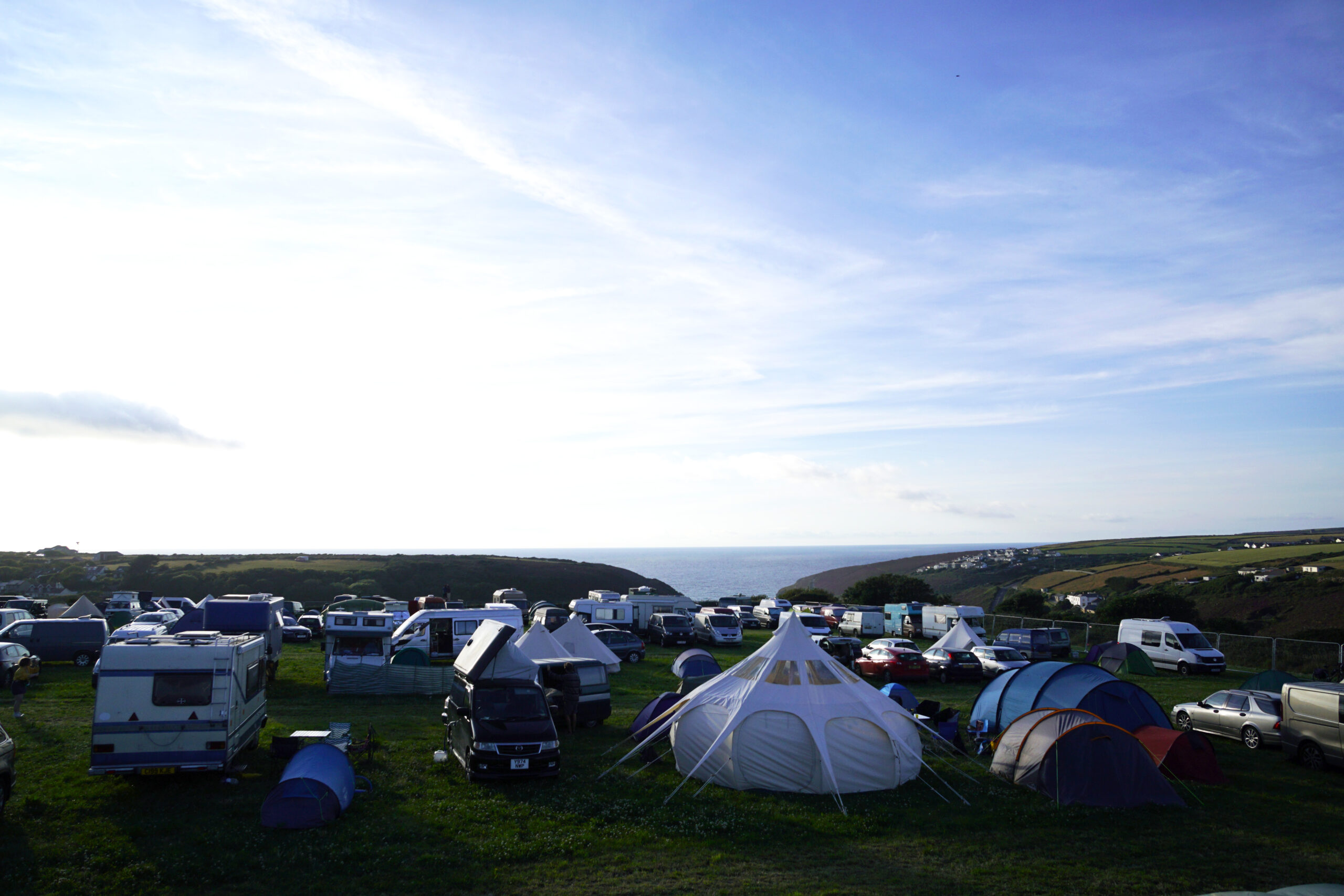 camping, tält och vans parkerade med utsikt över havet
