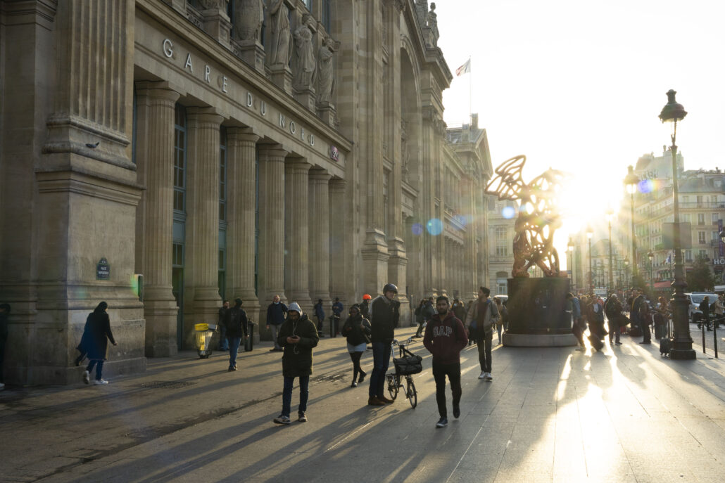 Människor utanför Gare du Nord i Paris i morgonsol
