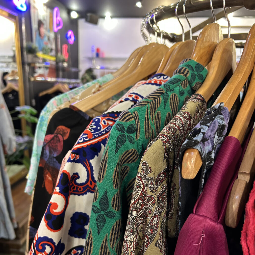 Second hand kläder som hänger uppe i en butik