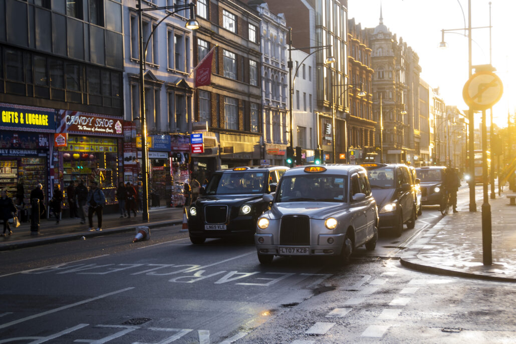 Taxibilar, butiker och människor på Oxford St i motstol.