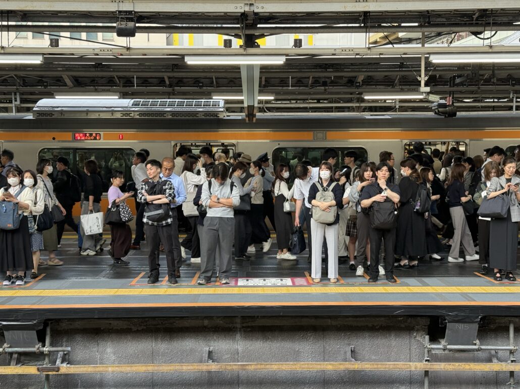 Människor på station som väntar på tåg i Tokyo
