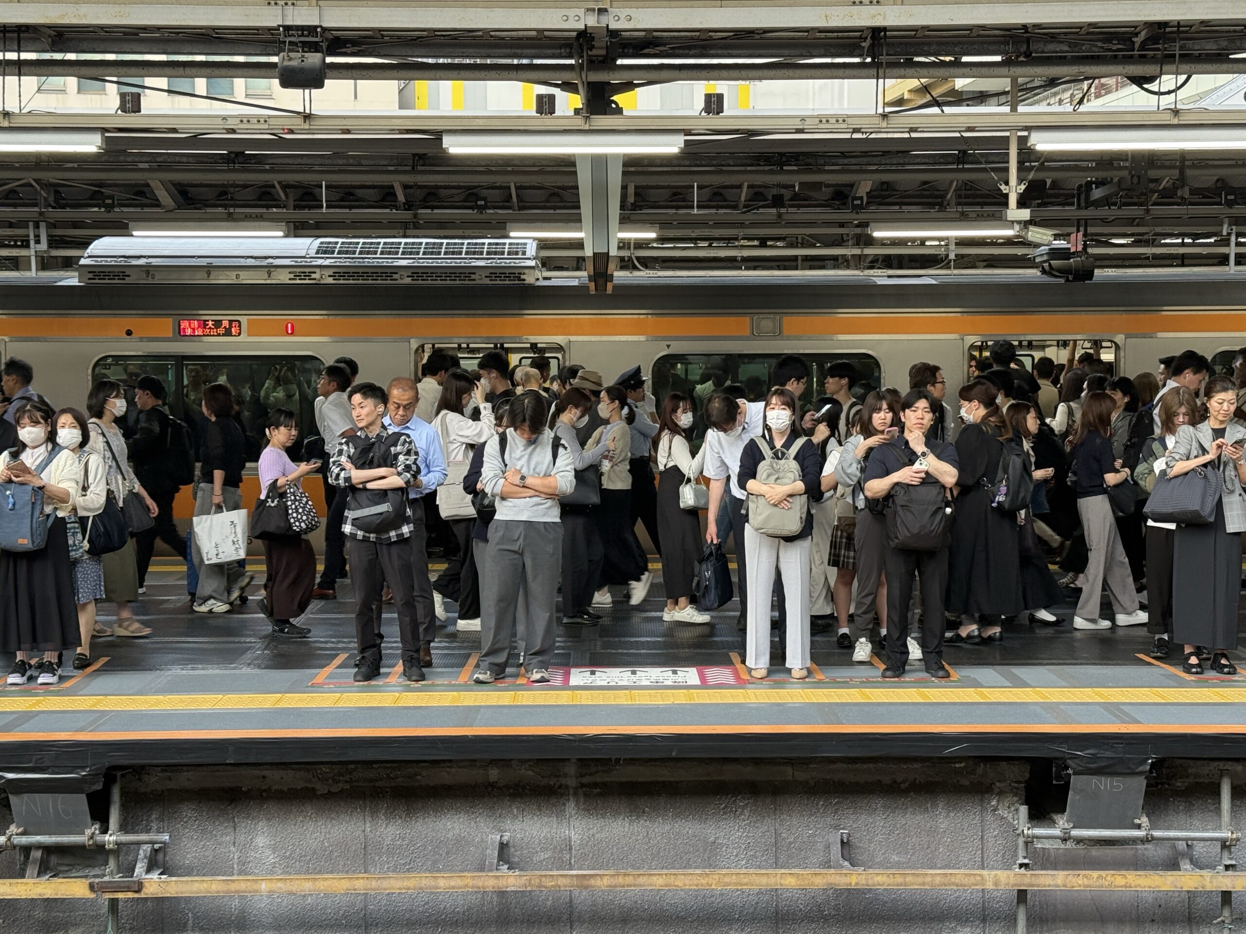 Människor på station som väntar på tåg i Tokyo
