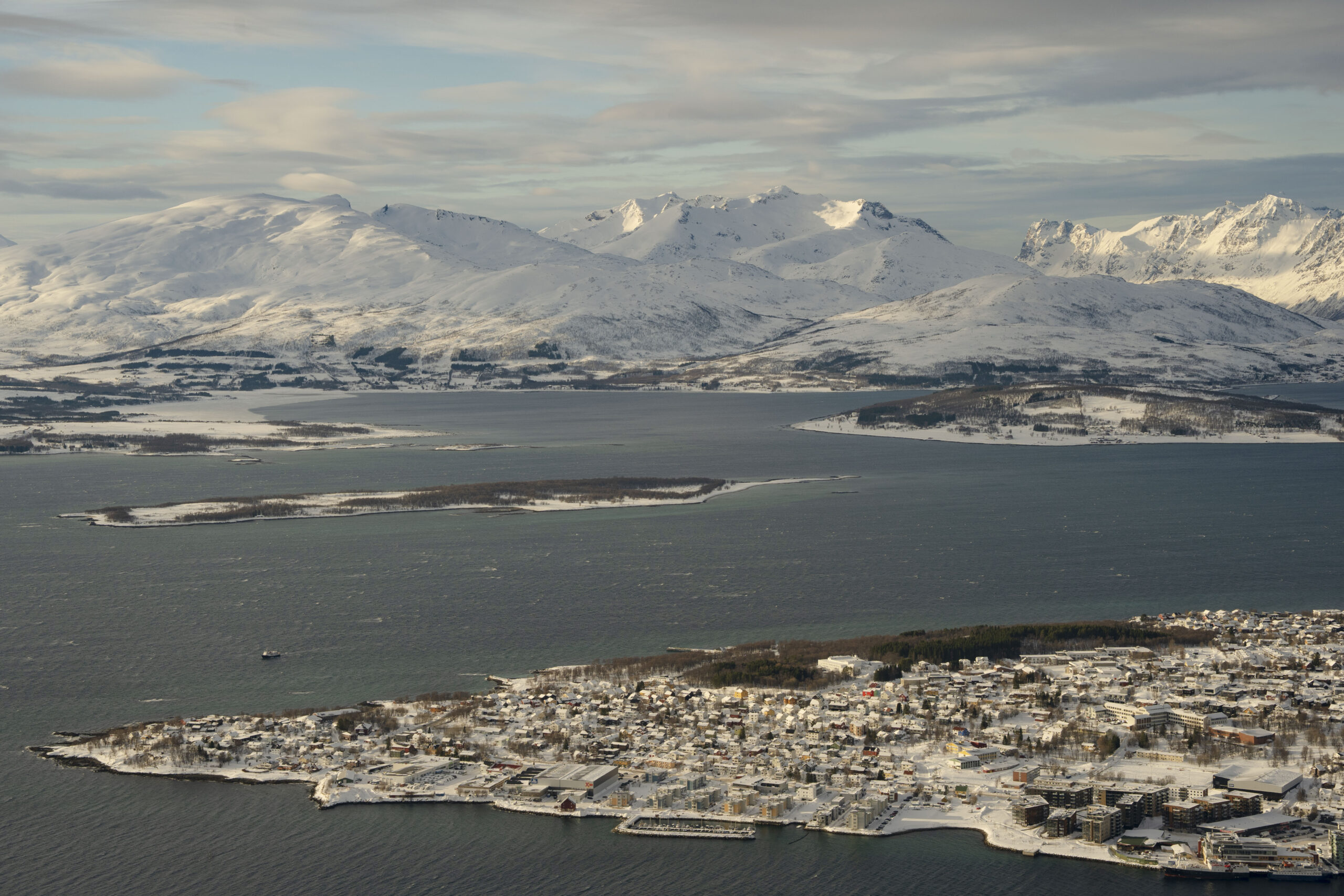 Översiktsvy över Tromsö i Norra Norge. Berg och hav i bakgrunden.