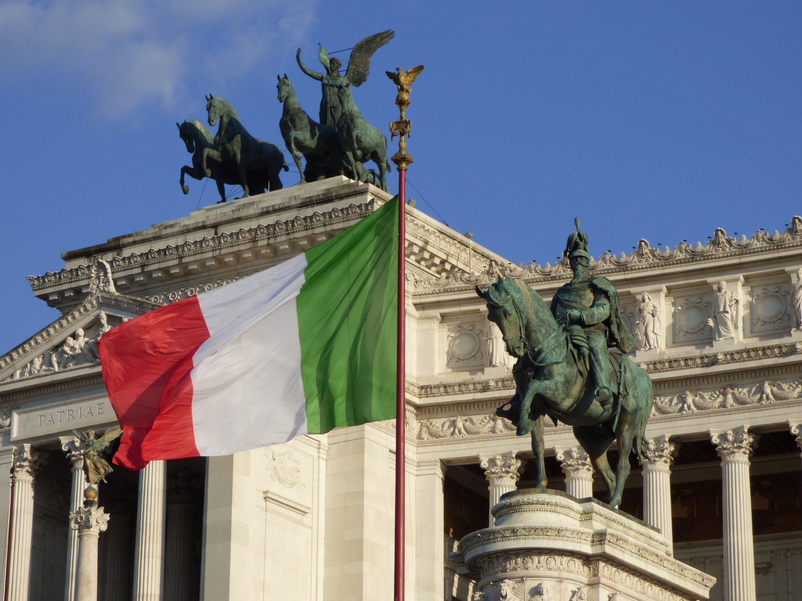 Italiensk flagga vajar vid Altare della Patria, som visar upp romersk arkitektur och historiska monument.